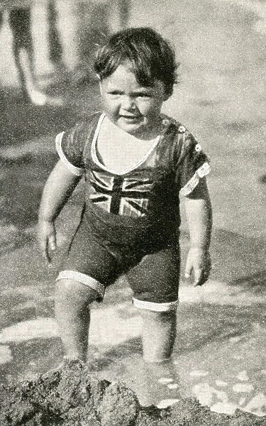 Little boy at the seaside in patriotic British swimsuit