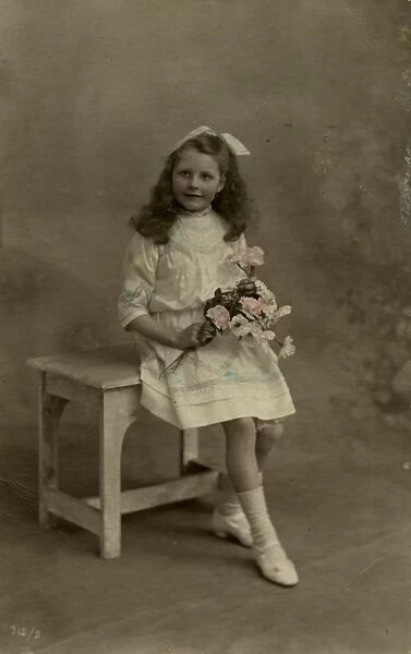 Little girl with bunch of pink roses