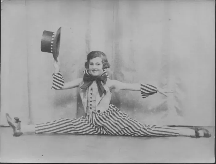 Framed Print : A little girl does the splits in a jolly stage costume of striped trousers and top hat Framed Print : A little girl does the splits in a jolly stage costume of striped trousers and top hat