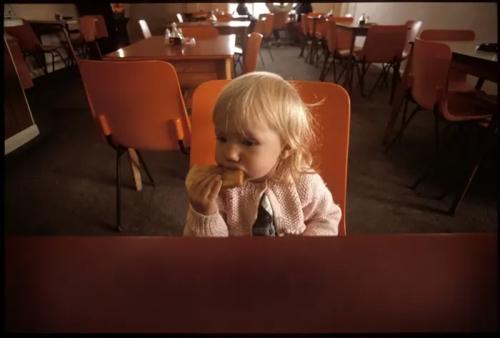 Framed Print : A Little girl eating toast in a cafe Framed Print : A Little girl eating toast in a cafe
