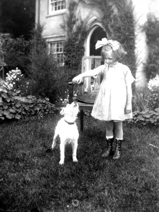 Framed Print : Little girl in a garden with a small dog Framed Print : Little girl in a garden with a small dog