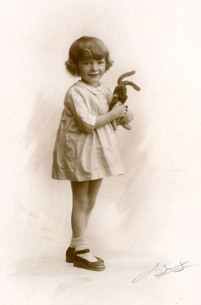 Little girl holds a toy rabbit, circa 1930s