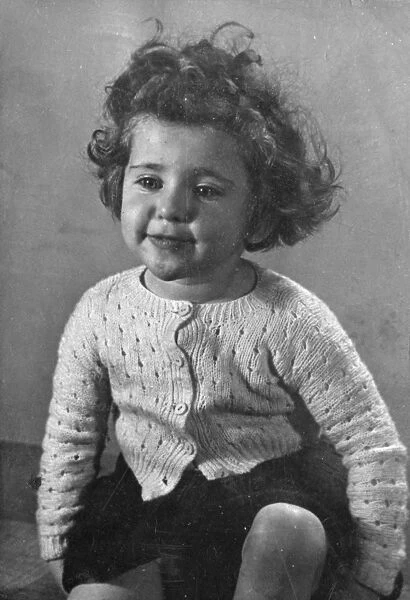 Little girl in a knitted cardigan, smiling