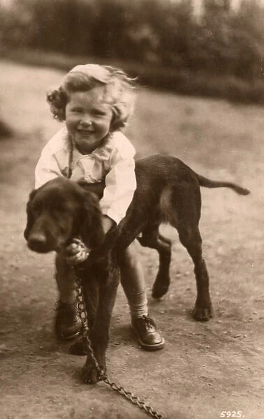 Little girl with a large puppy in a garden