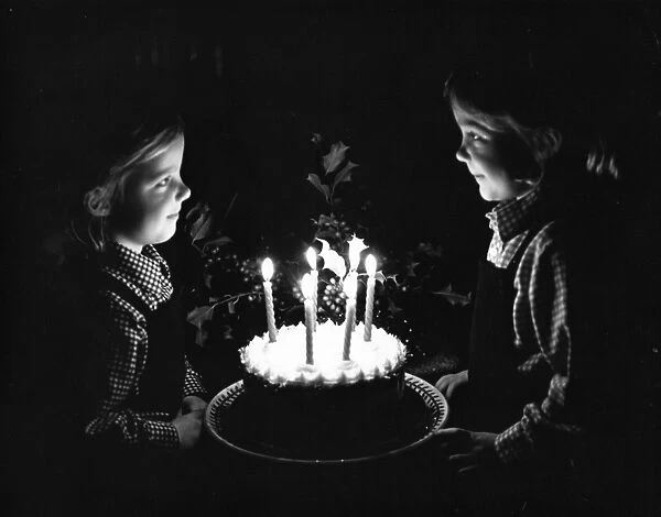 Two little girls with a birthday cake