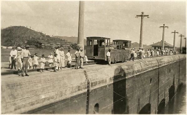 Locals gather along the canal to see the passing of a ship