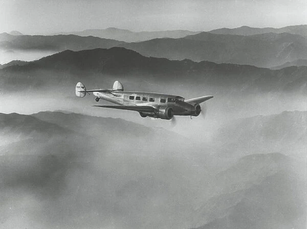 Lockheed L-10 Electra above misty hills