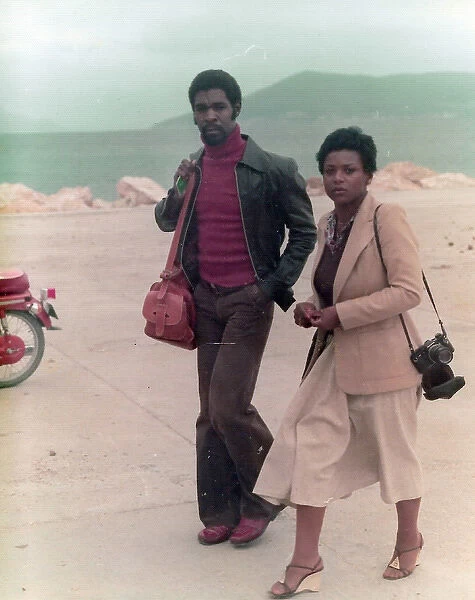 Lorna & Errol Holder walking along the dock of a Greek Islan