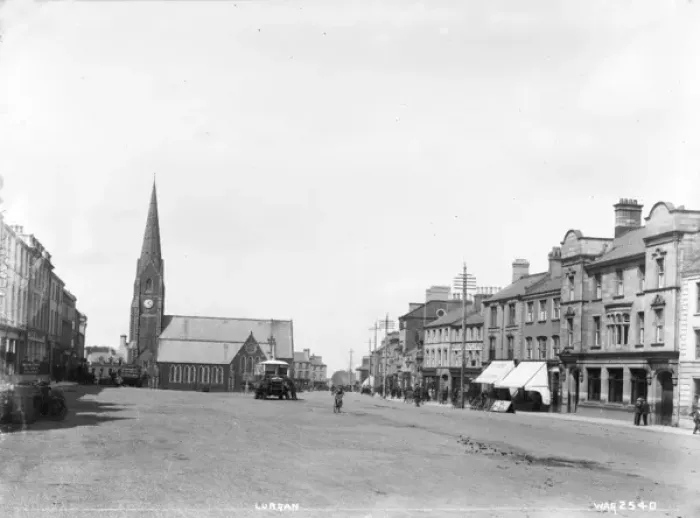 Framed Print : Lurgan - a street scene with motor bus and people and shop fronts and church Framed Print : Lurgan - a street scene with motor bus and people and shop fronts and church
