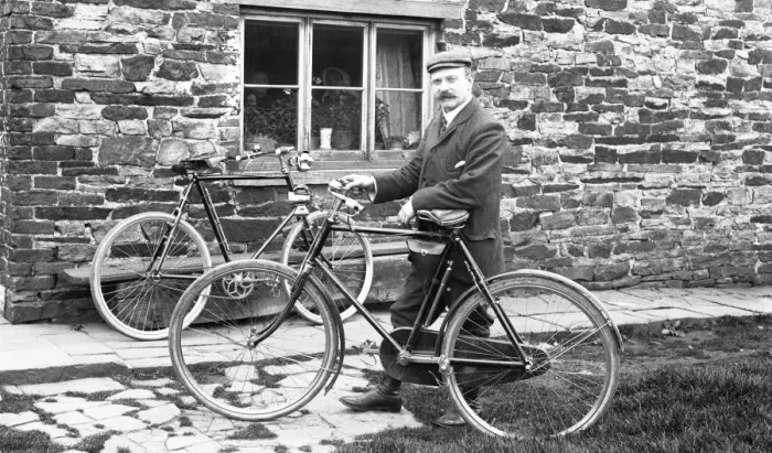 Framed Print : Man with bicycles outside house Framed Print : Man with bicycles outside house