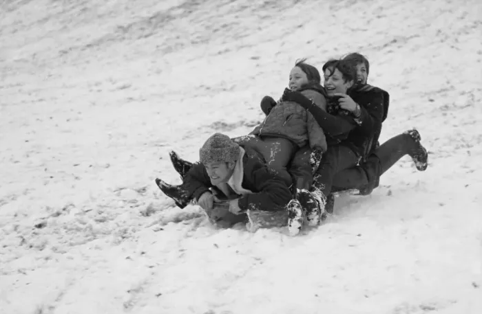 Framed Print : Man and three children on a toboggan in the snow Framed Print : Man and three children on a toboggan in the snow