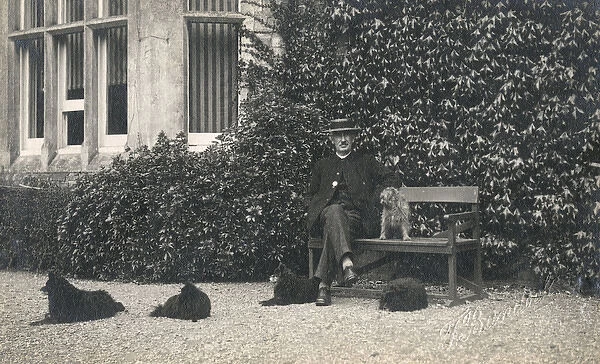 Man and four dogs outside a large house