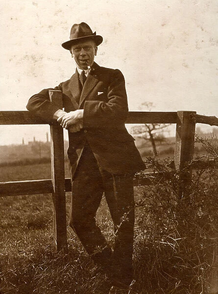 Man leaning on a fence in the countryside