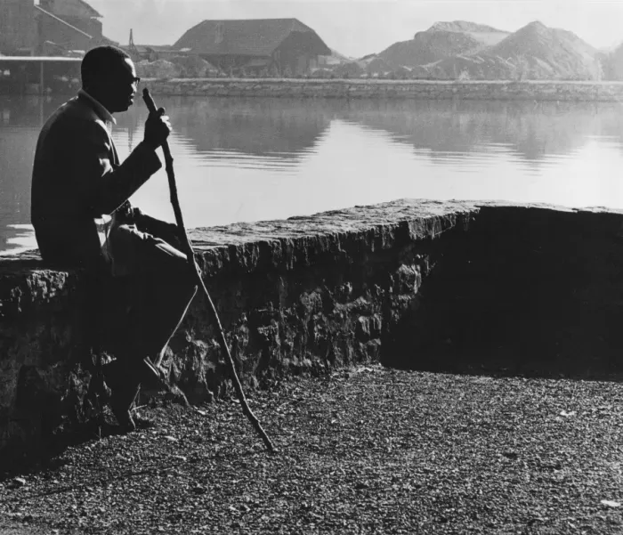 Framed Print : Man sitting on a wall by a stretch of water Framed Print : Man sitting on a wall by a stretch of water