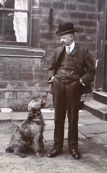 Man with terrier dog outside a building