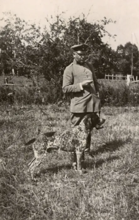 Framed Print : Man in uniform with a dog in a field, Germany Framed Print : Man in uniform with a dog in a field, Germany