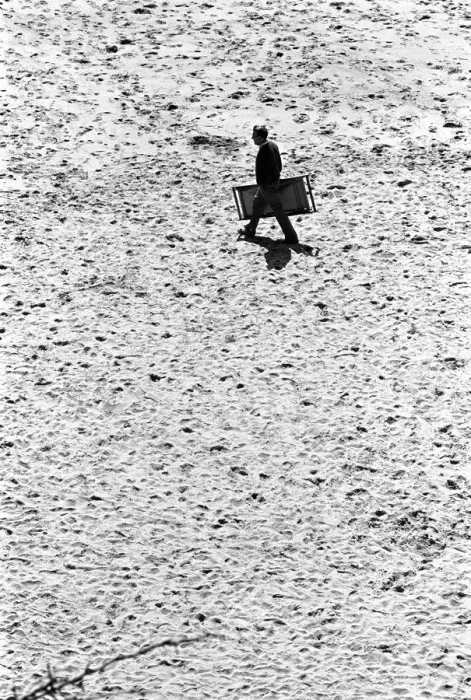 Framed Print : Man walks across Tenby beach carrying a deck chair Framed Print : Man walks across Tenby beach carrying a deck chair