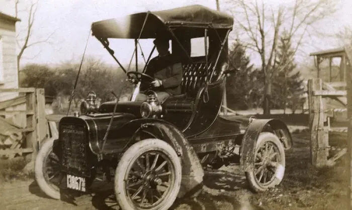Framed Print : Man at the wheel of an early car, USA