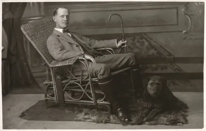 Framed Print : Man in wickerwork chair with pet dog Framed Print : Man in wickerwork chair with pet dog