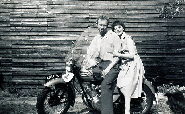 Man & woman on 1950s Triumph motorcycle