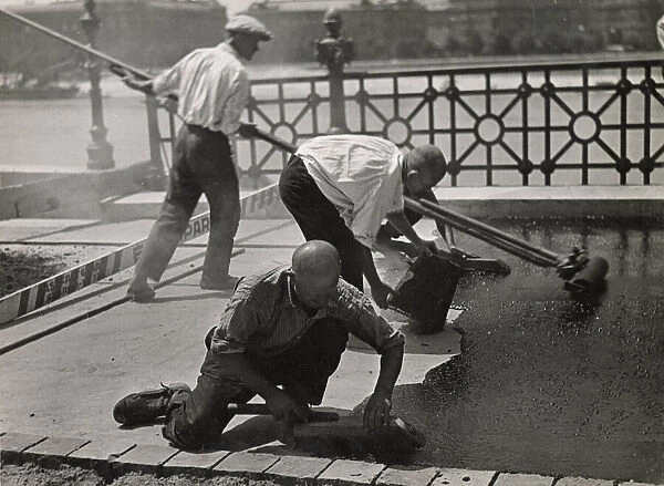 Men asphalting a street. Date: 1930s