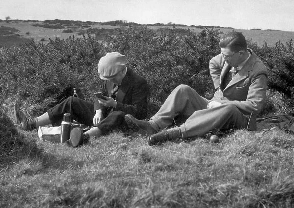 Two men enjoying a hilltop picnic