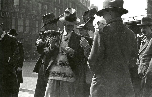 Men feeding pigeons in a London street