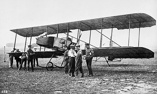 Men in a field with an early biplane