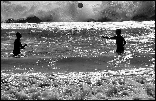Men playing with a ball in heavy surf