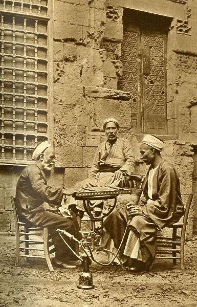Men playing game of draughts in a courtyard, Egypt