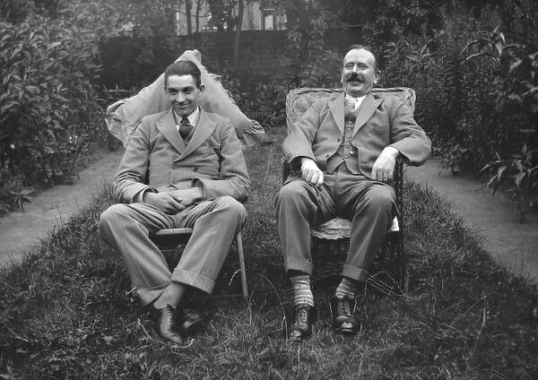 Two men sitting in a garden