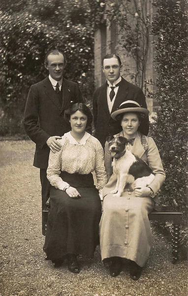 Two men, two women and dog in garden