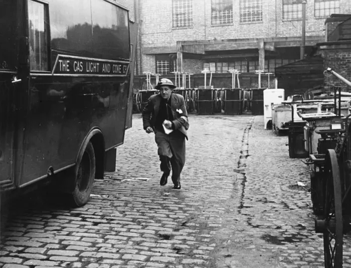 Framed Print : A messenger runs with the news that a gas main is on fire after an air raid during World Framed Print : A messenger runs with the news that a gas main is on fire after an air raid during World