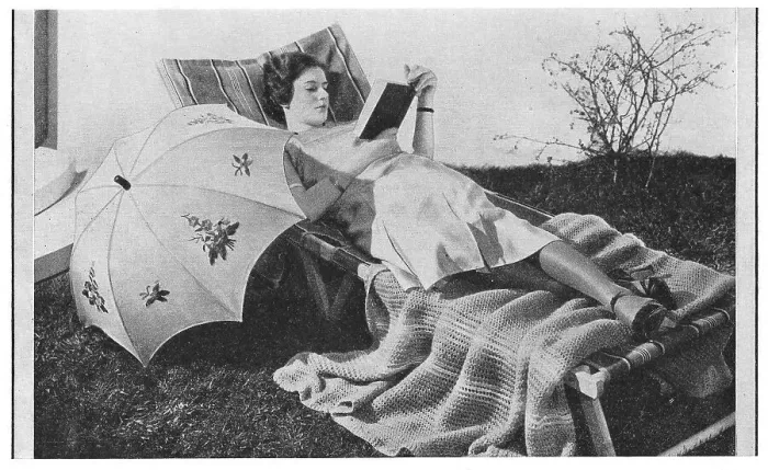 Framed Print : Model reading on a garden lounger with an umbrella, wearing very thick silk stockings, advertising patterns for an embroidered sunshade and knitted blanket. Date: 1935 Framed Print : Model reading on a garden lounger with an umbrella, wearing very thick silk stockings, advertising patterns for an embroidered sunshade and knitted blanket. Date: 1935