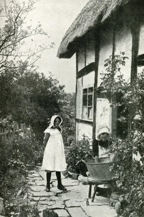 Framed Print : Mother and daughter outside a thatched cottage, England Framed Print : Mother and daughter outside a thatched cottage, England