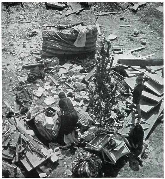 Mother searching for her belongings in debris 1939