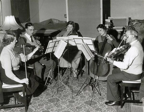 A musical quintet rehearse a piece of classical music. Date: 1930s