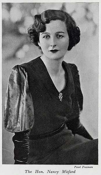 Nancy Mitford, formal studio portrait. With description, The Hon. Nancy Mitford; Whose latest novel, 'Christmas Pudding' was seasonably published a month or so ago, and was even more witty and amusing than her first book