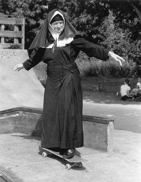 Nun on a skateboard, holding her arms out for balance. Date: circa 1970s
