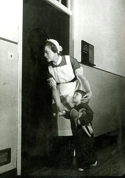Nurse holding childs hand, looking in on an operation