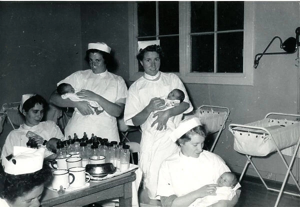 Nurses with babies in hospital nursery