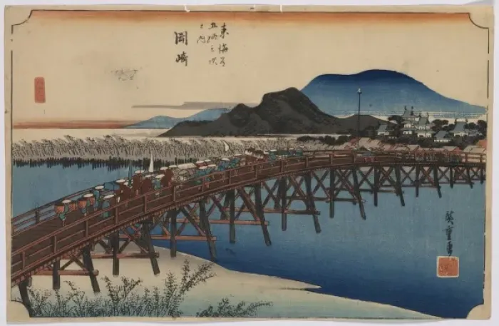 Framed Print : Okazaki. Print shows travelers on a bridge across a river with buildings Framed Print : Okazaki. Print shows travelers on a bridge across a river with buildings