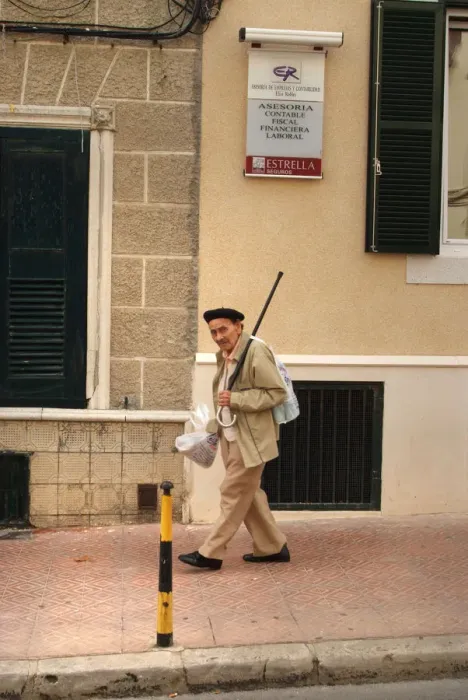 Framed Print : An old man walks down a street in Menorca, Spain Framed Print : An old man walks down a street in Menorca, Spain