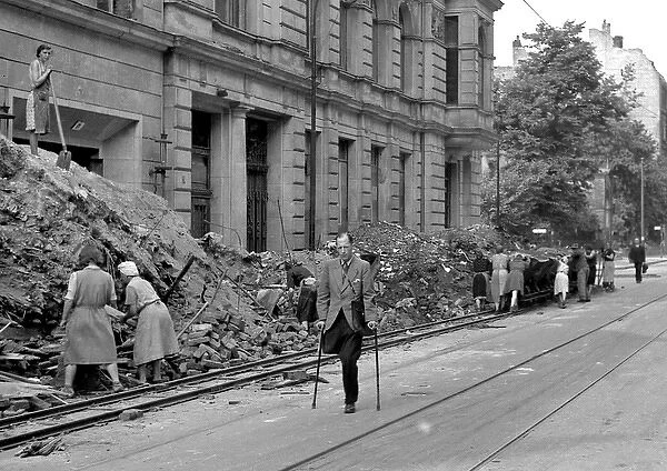 People in a bomb damaged street during WW2