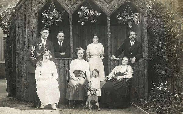 Eight people with a dog in a garden