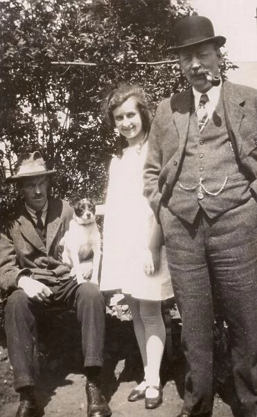 Three people and a dog in a garden