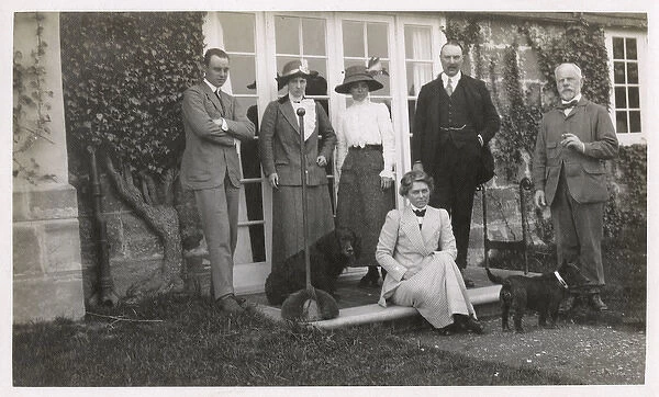 Six people with two dogs in a garden