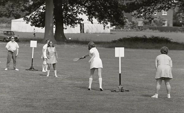 Five people playing a ball game in a field