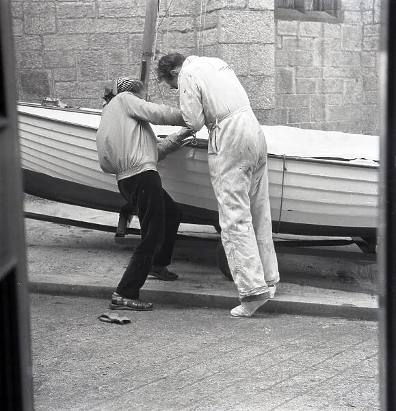 Two people preparing a sailing dinghy