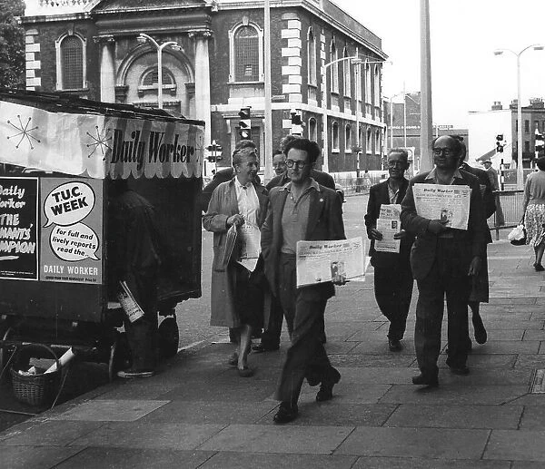 People on street with Daily Worker newspaper, London